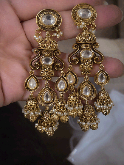 Oval kundan in center of shell ghunghru hangings intricately carved choker set with tear shaped kundan line