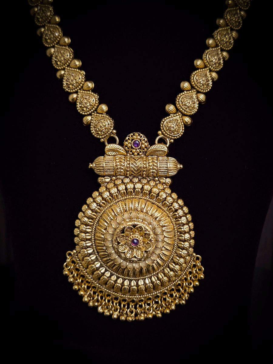 Circular pendant with ruby stone flower in center 10" long leaf design string set