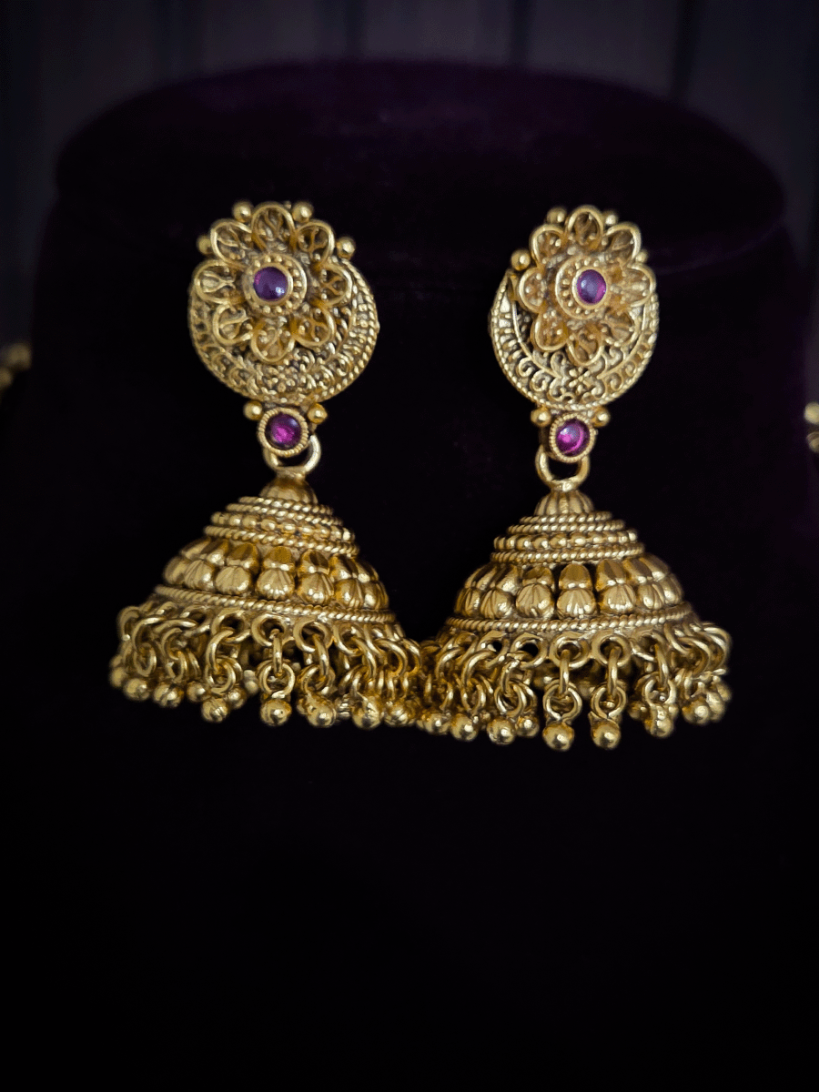 Circular pendant with ruby stone flower in center 10" long leaf design string set