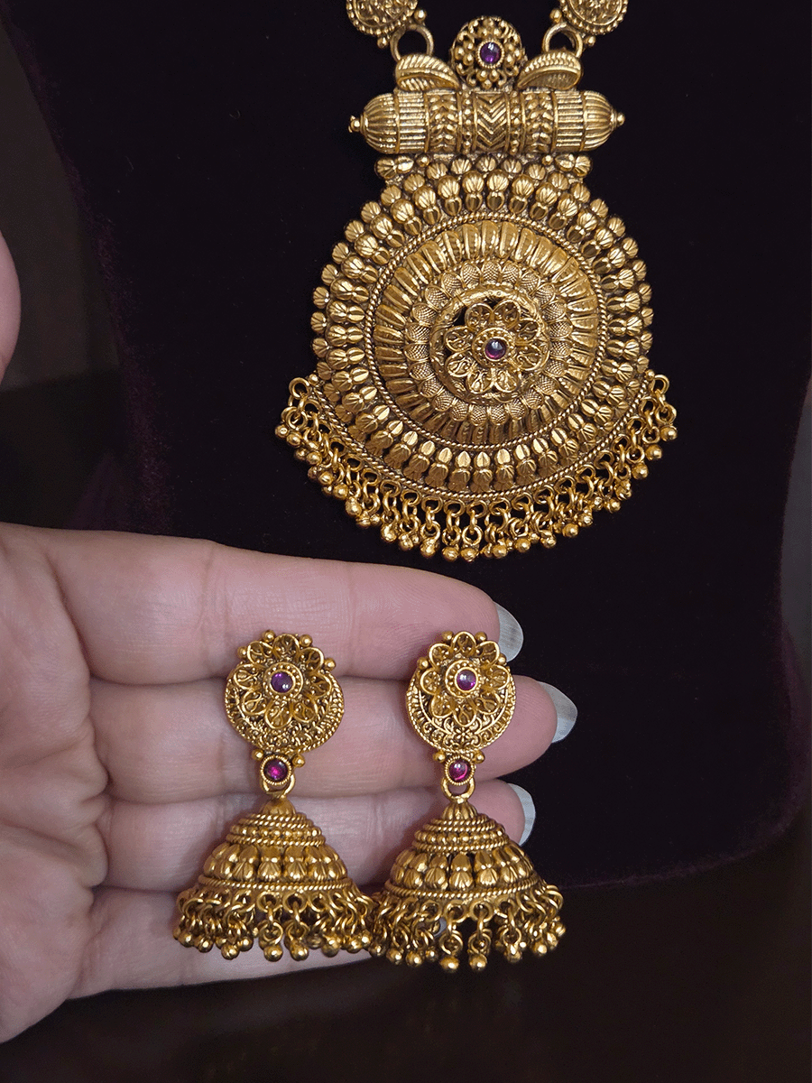 Circular pendant with ruby stone flower in center 10" long leaf design string set