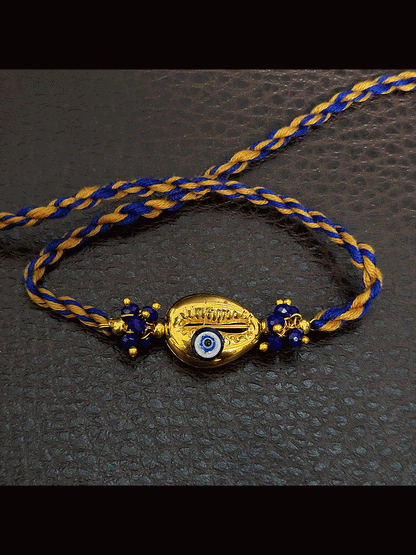 Golden shell with blue evil eye blue and brown thread rakhi