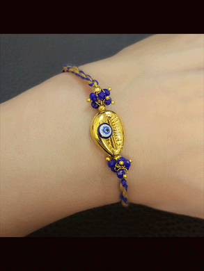 Golden shell with blue evil eye blue and brown thread rakhi