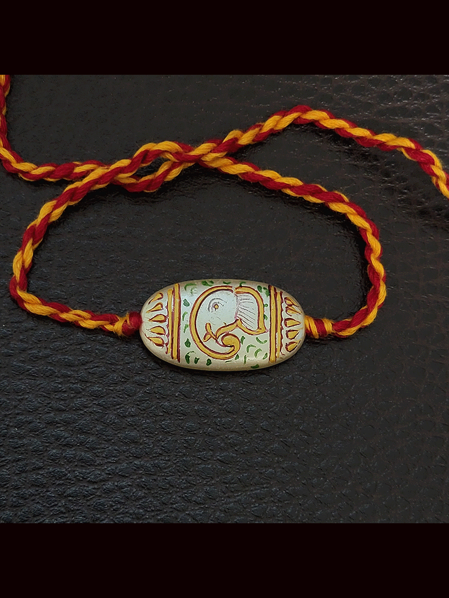 Hand painted ganpati design white oval bead rakhi(approx.1inches bead)
