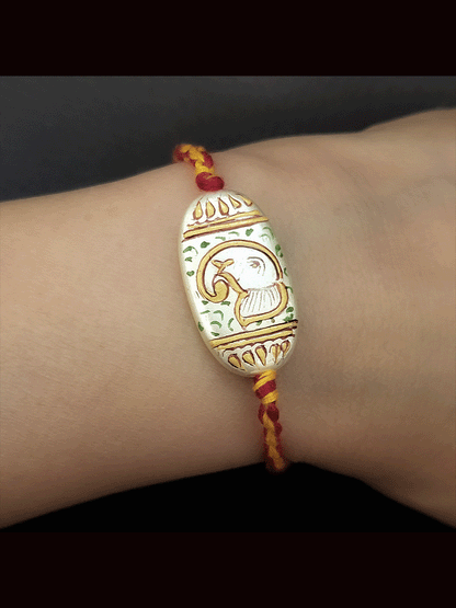 Hand painted ganpati design white oval bead rakhi(approx.1inches bead)