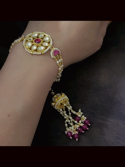 Coloured stone in the center of round paachi kundan bhabhi or sister rakhi with jhoomki tassel