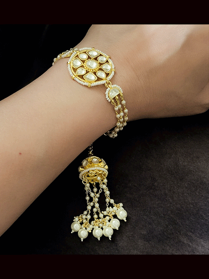 Coloured stone in the center of round paachi kundan bhabhi or sister rakhi with jhoomki tassel