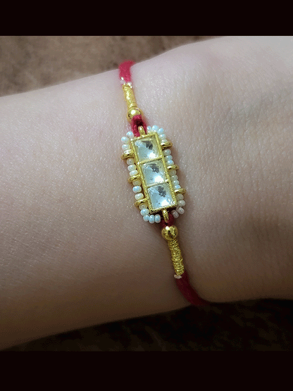 Three paachi kundan pirohi work coloured stones and coloured thread rakhi