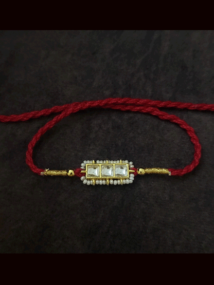 Three paachi kundan pirohi work coloured stones and coloured thread rakhi