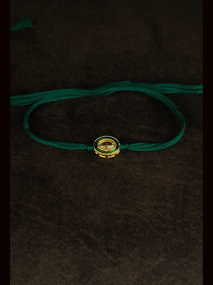 Oval brown stone with green enamel outline with green thread bhai rakhi
