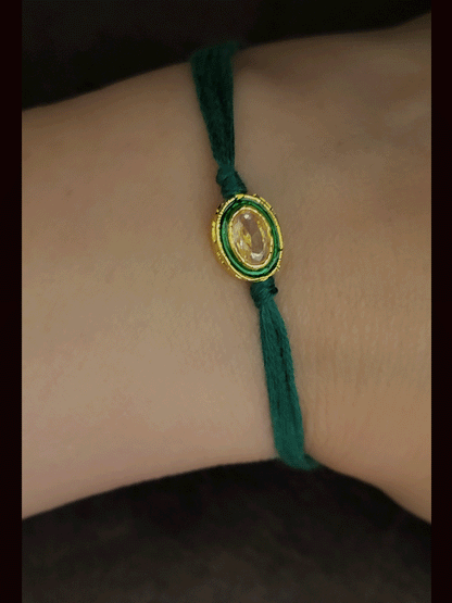 Oval brown stone with green enamel outline with green thread bhai rakhi