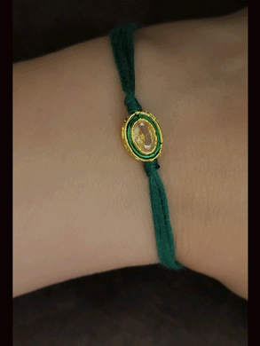 Oval brown stone with green enamel outline with green thread bhai rakhi