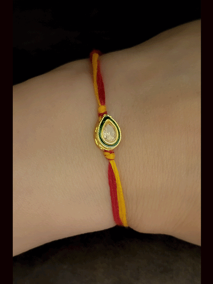 Leaf shaped brown stone with green enamel outline bhai rakhi in mauli thread