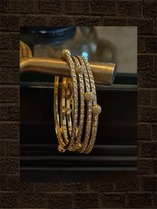 Set of four gold and rhodium plated bangles with self dotted design and gold beads - Odara Jewellery