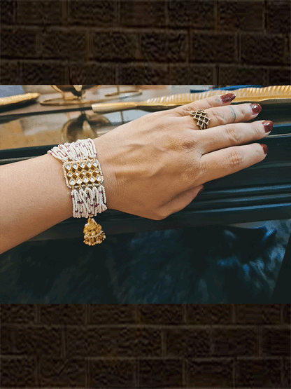 Rectangular kundan tukdi with multiple cheed strings bracelet rakhi with ruby and green bead detailing and hanging kundan jhoomki - Odara Jewellery