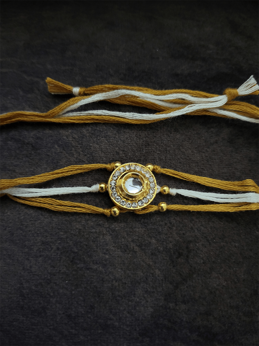 Circular kundan and AD rakhi with brown and white thread - Odara Jewellery