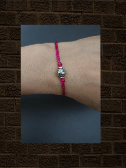 Sterling silver self design round bead rakhi in magenta thread - Odara Jewellery