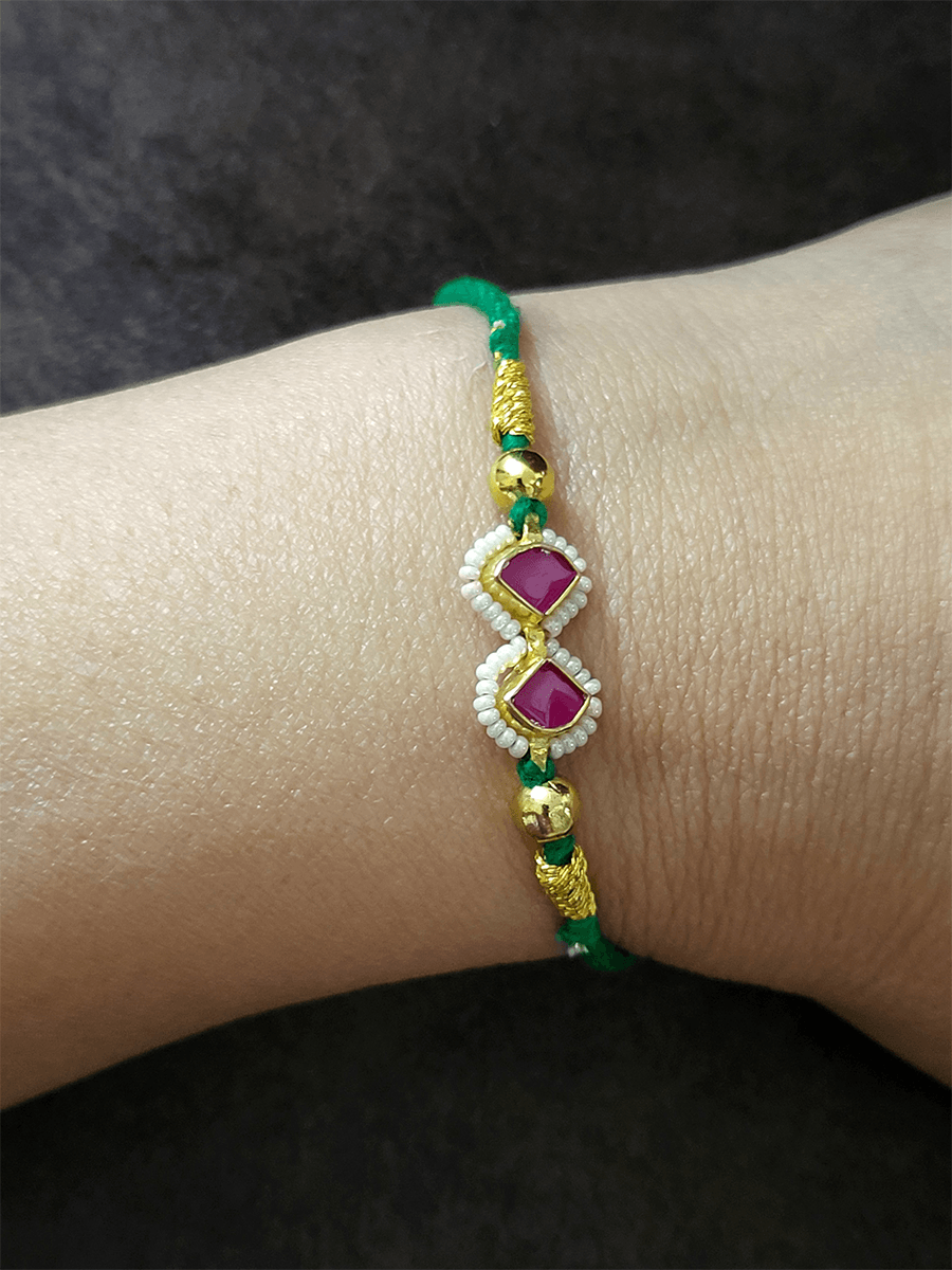 Ruby triangular stones pirohi work green thread rakhi - Odara Jewellery