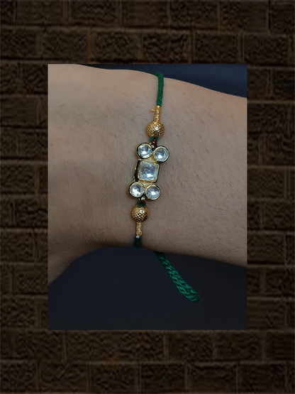 Kundan rakhi with gold bead in red and green thread - Odara Jewellery