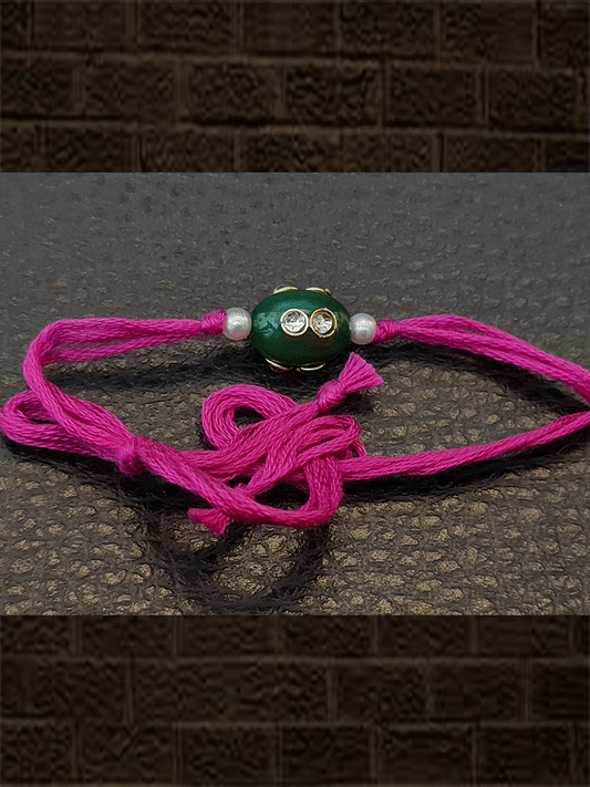 Oval green glass bead kundan with side pearl  rakhi in magenta thread - Odara Jewellery