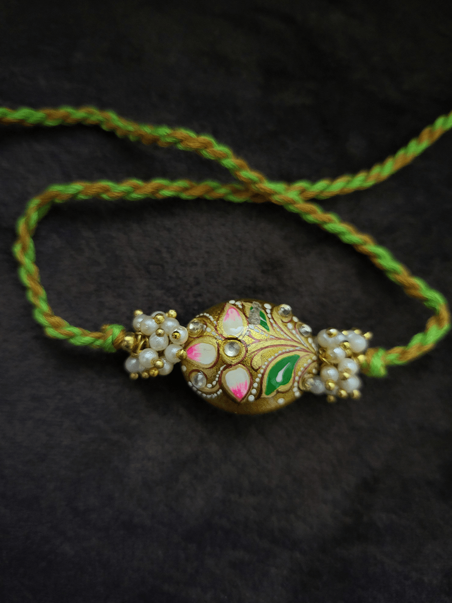 Hand painted flower on gold bead rakhi with pearly cluster on sides - Odara Jewellery