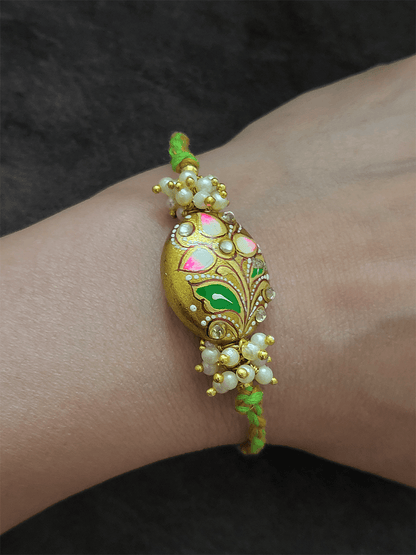 Hand painted flower on gold bead rakhi with pearly cluster on sides - Odara Jewellery