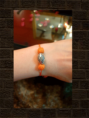 Sterling silver oval bead rakhi in Orange thread - Odara Jewellery